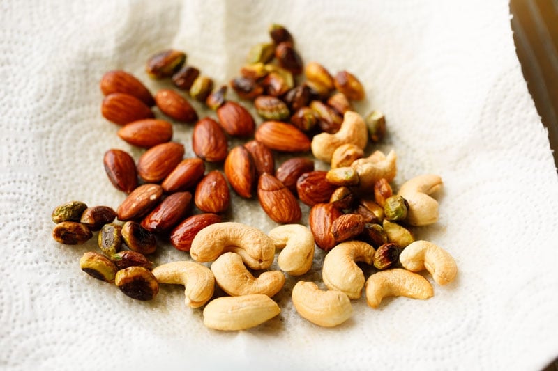 fried nuts placed on kitchen paper towel to drain for pinni recipe.