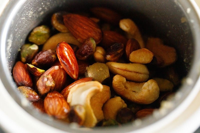 fried nuts added to mixer grinder to grind. 