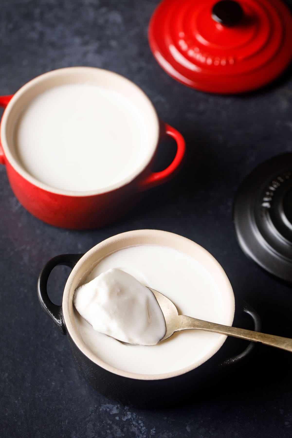 set curd in a red bowl with a spoon filled with curd with text layover.