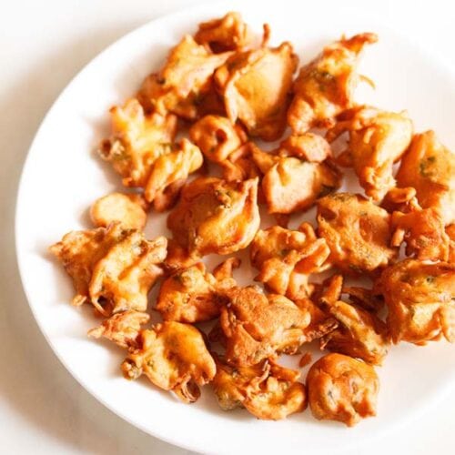 onion fritters served on a white plate.