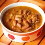 rajma curry in an orange and red dotted bowl.
