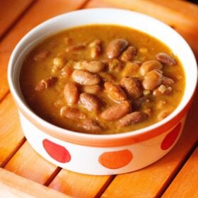 rajma curry in an orange and red dotted bowl.