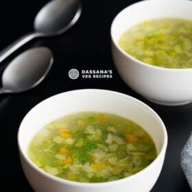 clear soup in two white bowls with two spoons on left side on a black table with text layovers.
