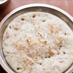 onion uttapam served on a steel plate with text layovers.