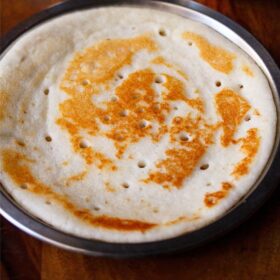 uttapam served on a steel plate.