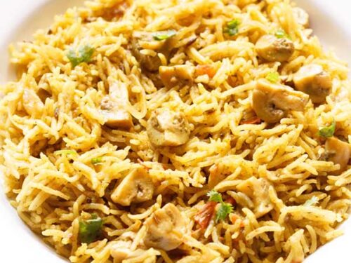 chettinad biryani on a blue rimmed white plate.