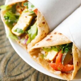paneer shawarma rolls on a white plate.