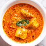 soya chaap masala in a white bowl with a mint sprig.