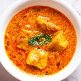 soya chaap masala in a white bowl with a mint sprig.