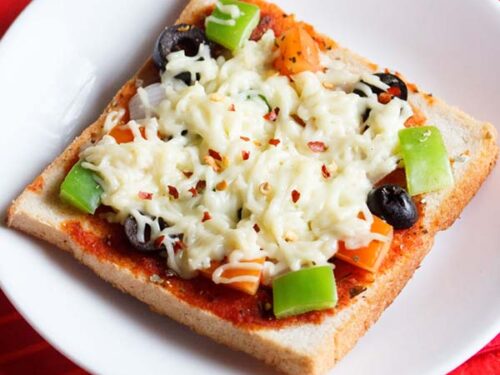 bread pizza slice on a white table with a red cloth underneath.