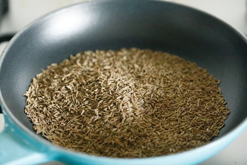 cumin seeds added in a frying pan.