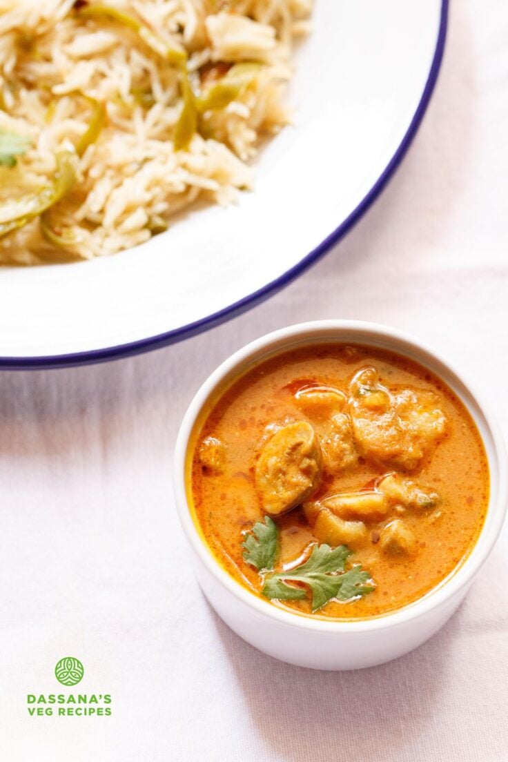 mushroom masala garnished with a coriander sprig in a white bowl placed on a white board.