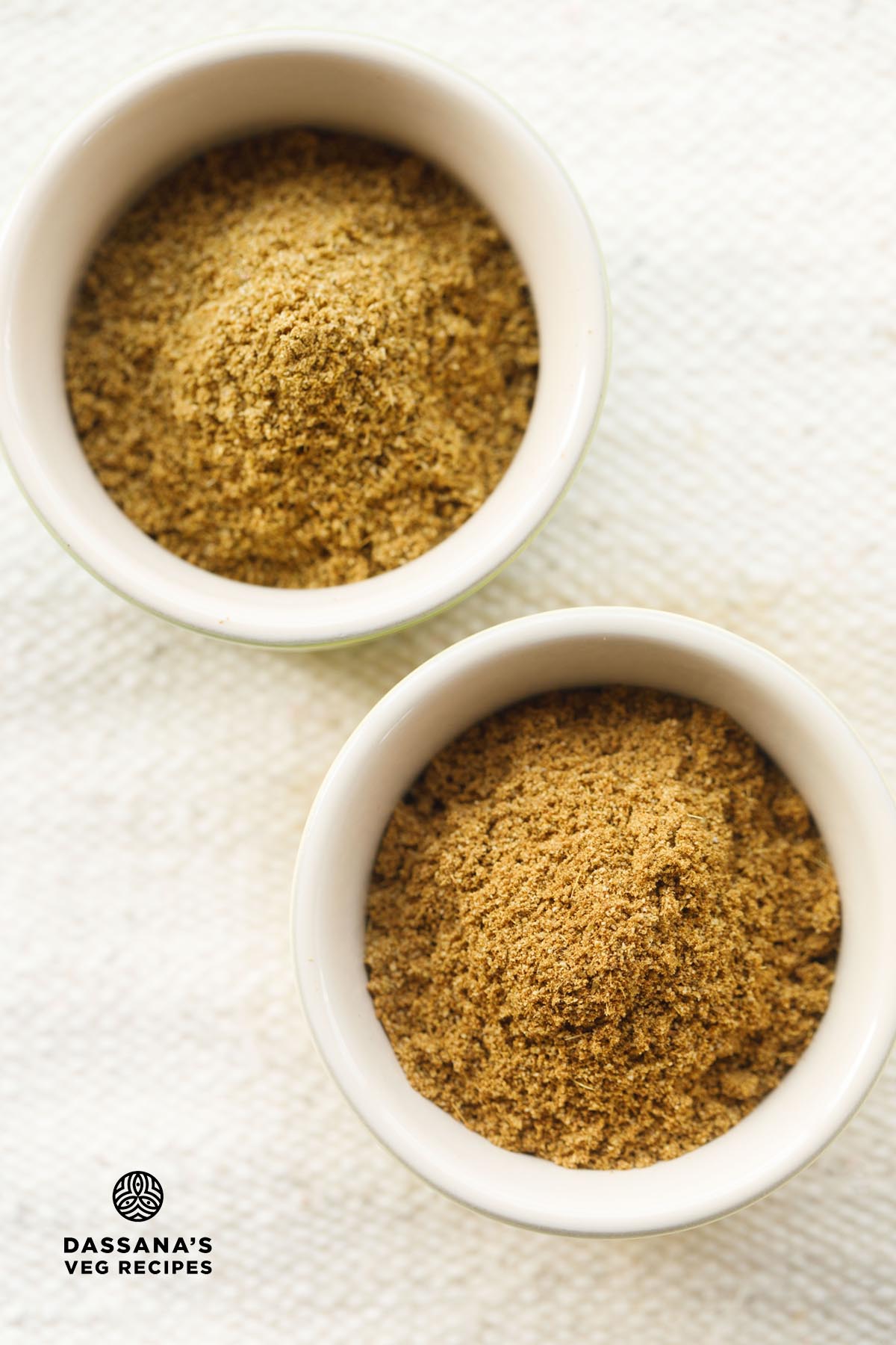 regular cumin powder and roasted jeera powder in two bowls on an off-white jute cloth.