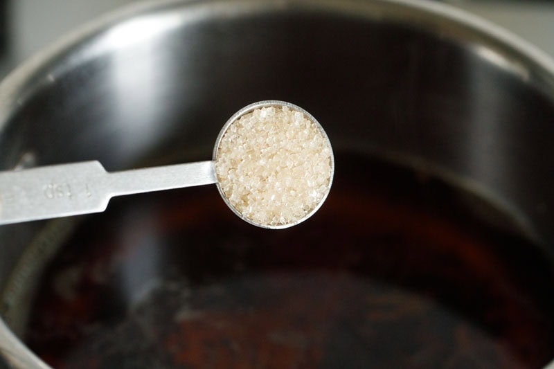 adding sugar to sulaimani chai. 