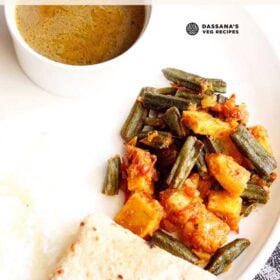 aloo bhindi served on a white plate with roti, steamed rice and dal with text layovers.