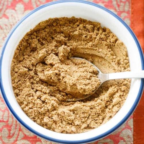 homemade chaat masala powder in a bowl with a spoon.