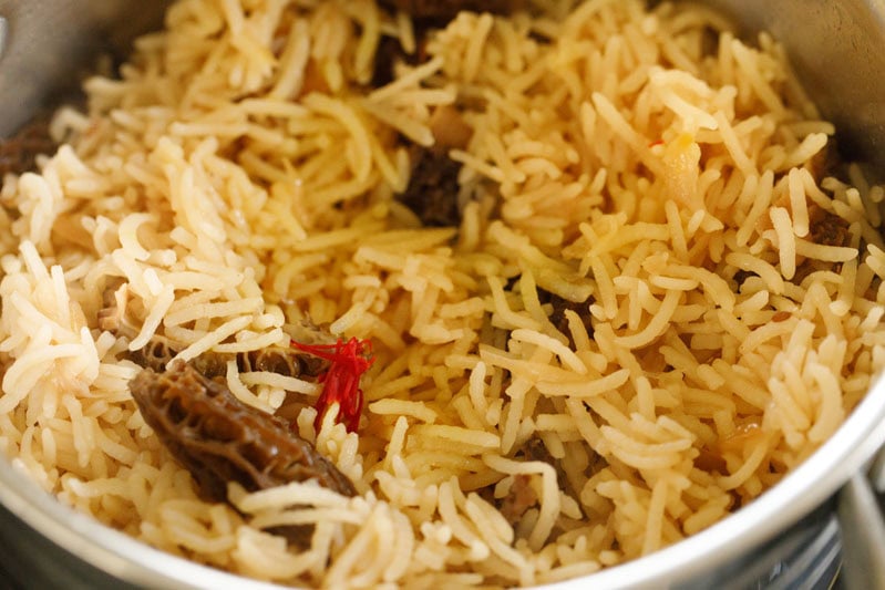 saffron water added to cooked gucchi pulao. 
