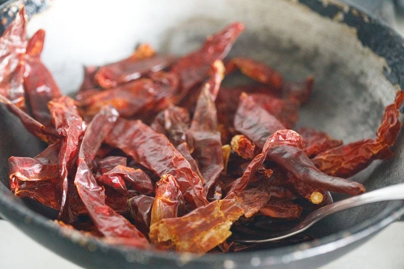 dry-roasting dried red chilies in hot pan.