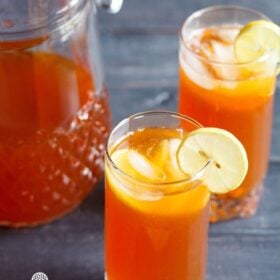 iced tea with lemon, ice cubes in two glasses with a pitcher full of the tea kept behind with text layovers.