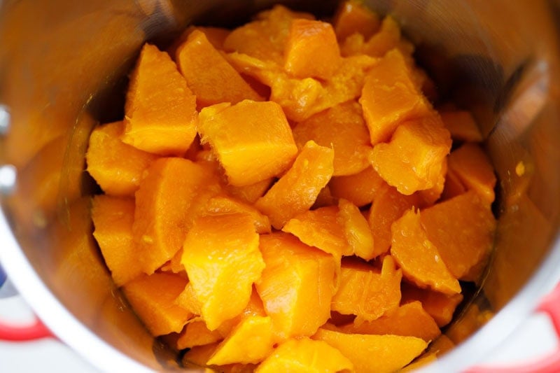 chopped mangoes added to a blender.