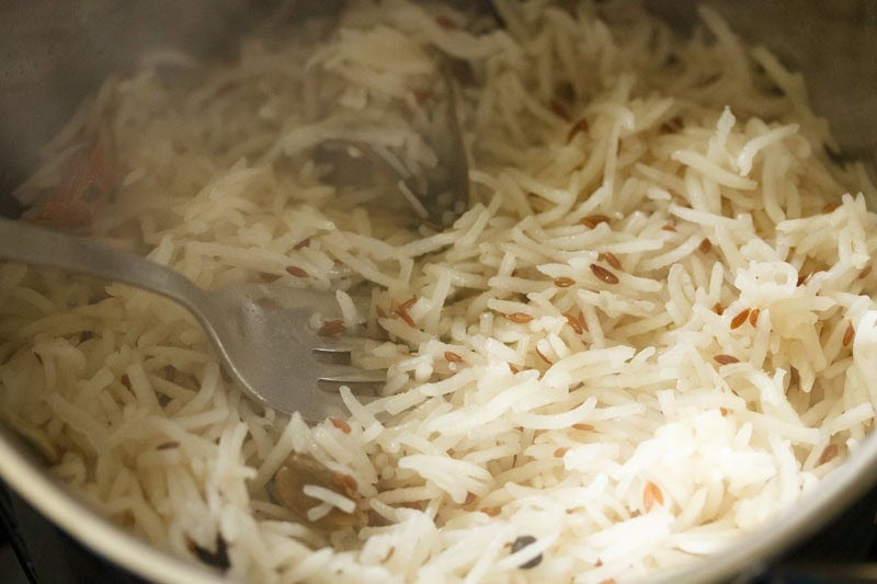 fluffing cooked jeera pulao.