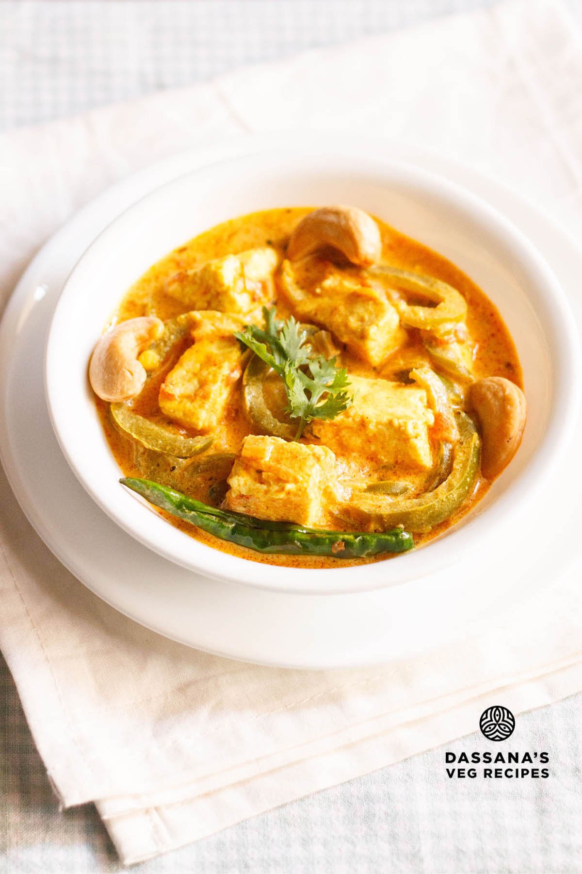 paneer sabji in a white bowl on off-white colored folded napkin.