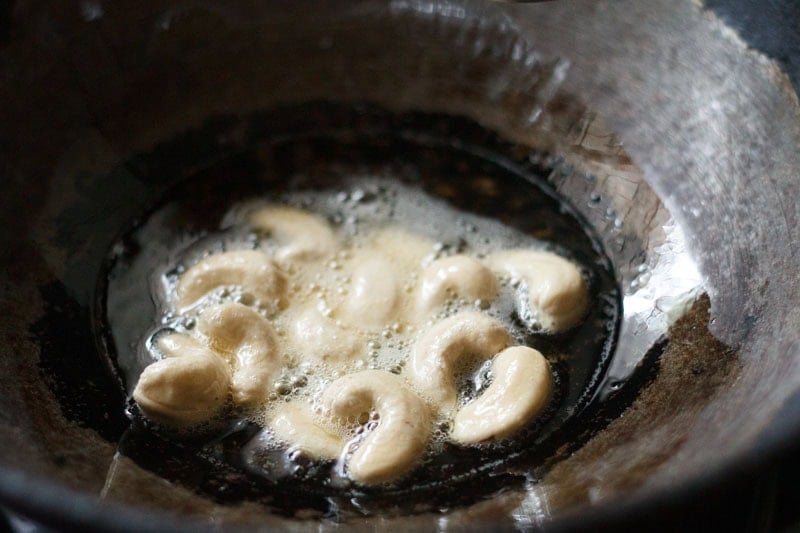 frying cashews in hot oil in kadai.
