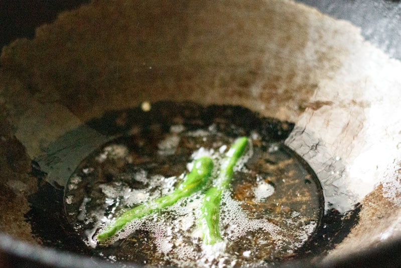 frying slit green chilies in the same oil.