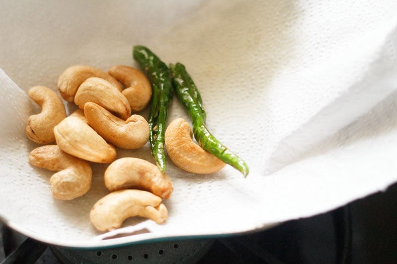 fried cashews and green chilies on paper towel.