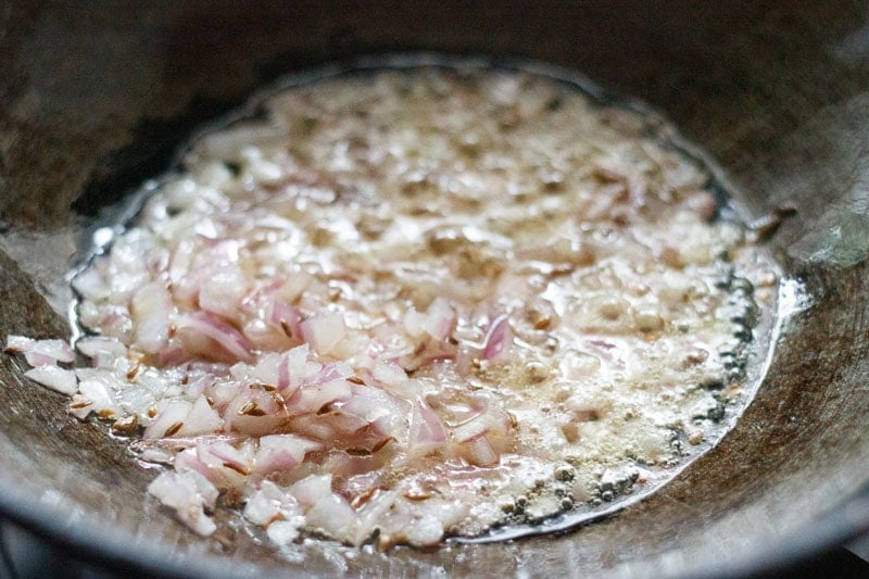 sautéing finely chopped onion in hot oil in kadai.
