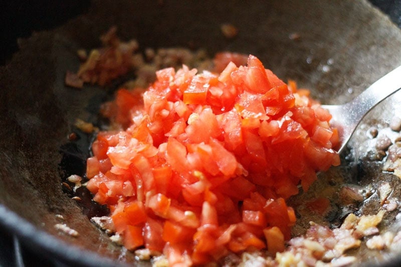 finely chopped tomatoes added to onions.