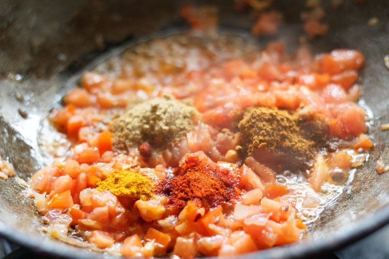 ground spices added to onion-tomato mixture.