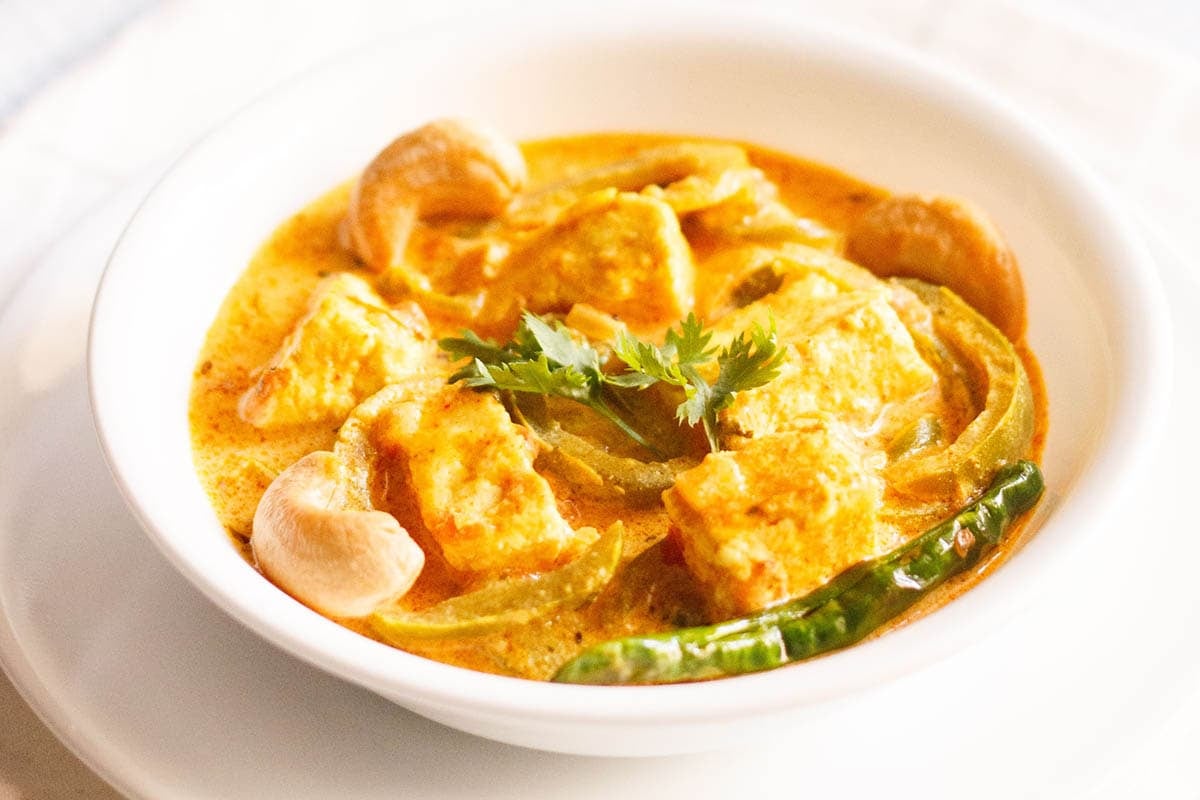 paneer sabji in a white bowl on a white plate.