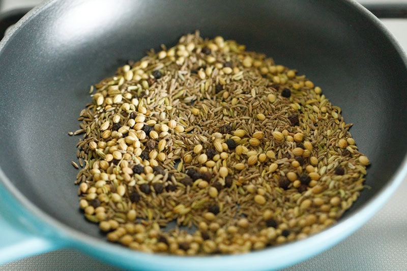 roasting whole spices in a pan for making chaat masala recipe.