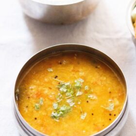 tomato dal in a steel bowl on white napkin with text layovers.
