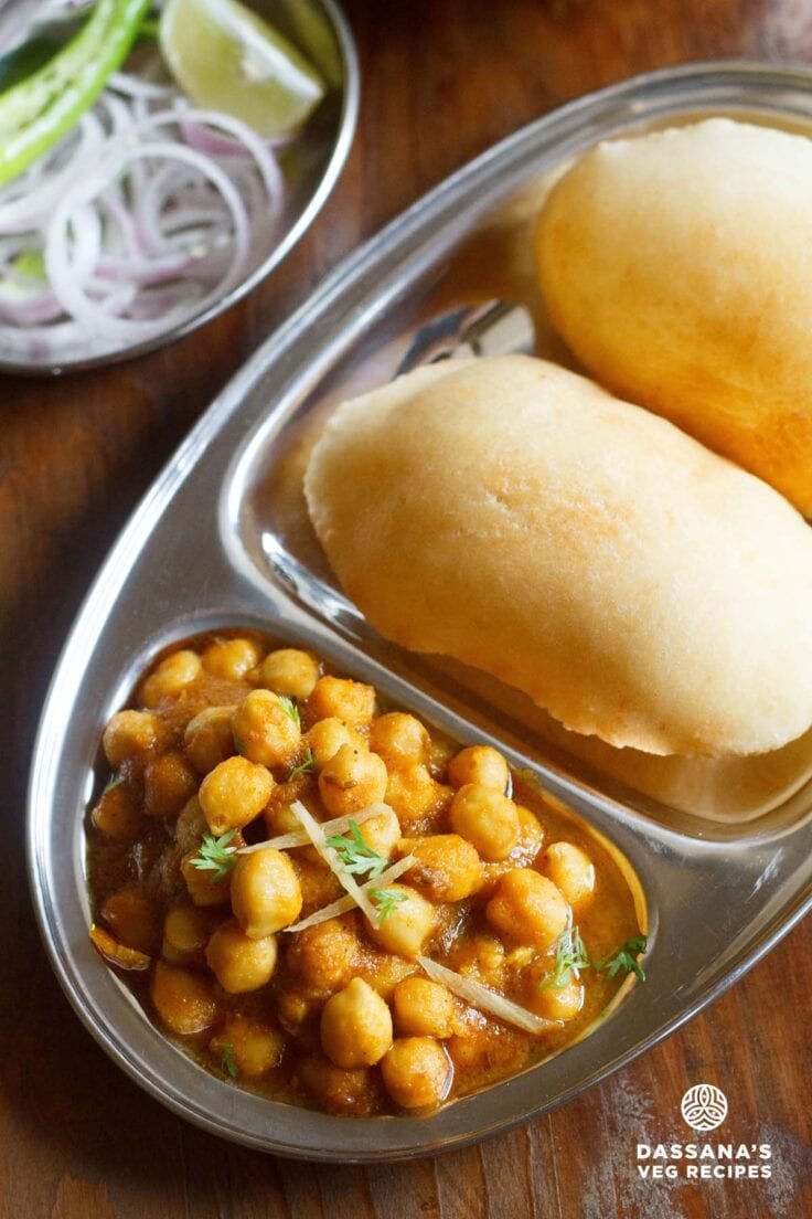 chole bhature on a plate with sections for chana curry and fried bread.