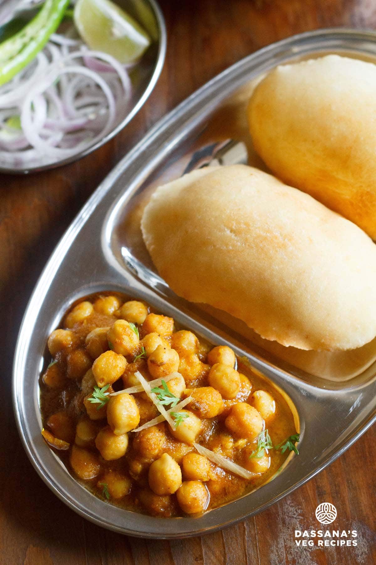 chole bhature on a plate with sections for chana curry and fried bread.