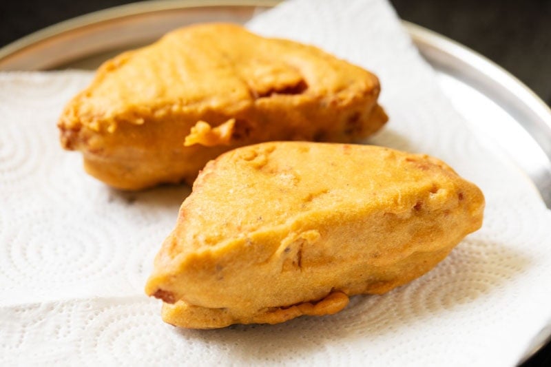 potato stuffed bread pakora placed on kitchen paper towels.