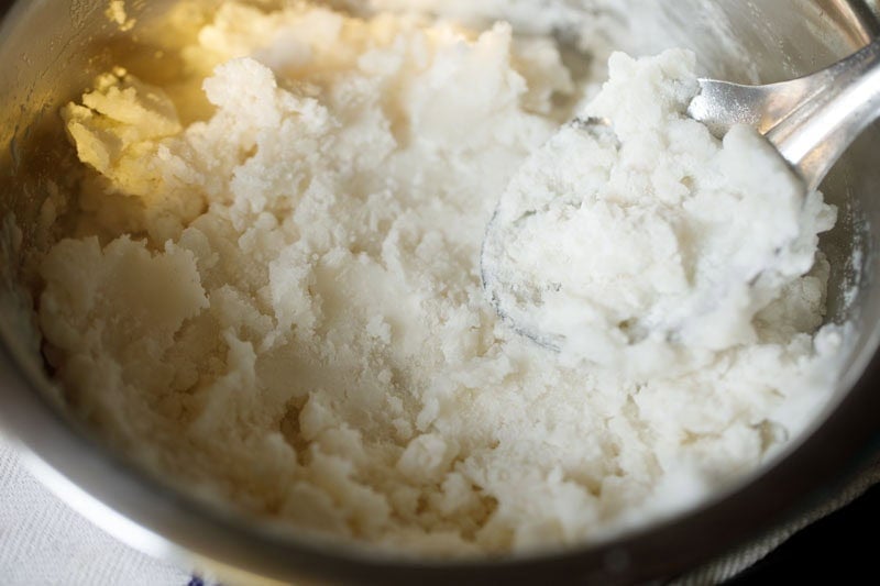 mixing water in rice flour with a spoon for idiyappam recipe.