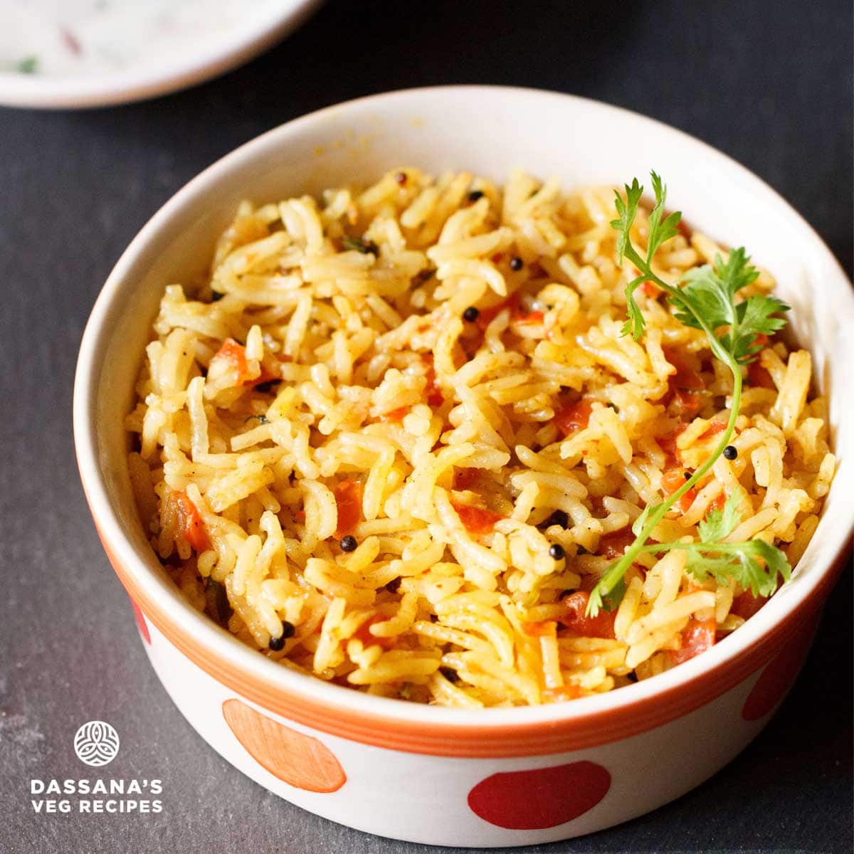 thakkali sadam served served in an orange and red dotted bowl on a dark black board.