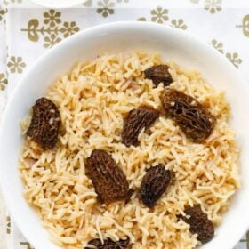 gucchi pulao (with morel mushrooms) in a white bowl with text layovers.