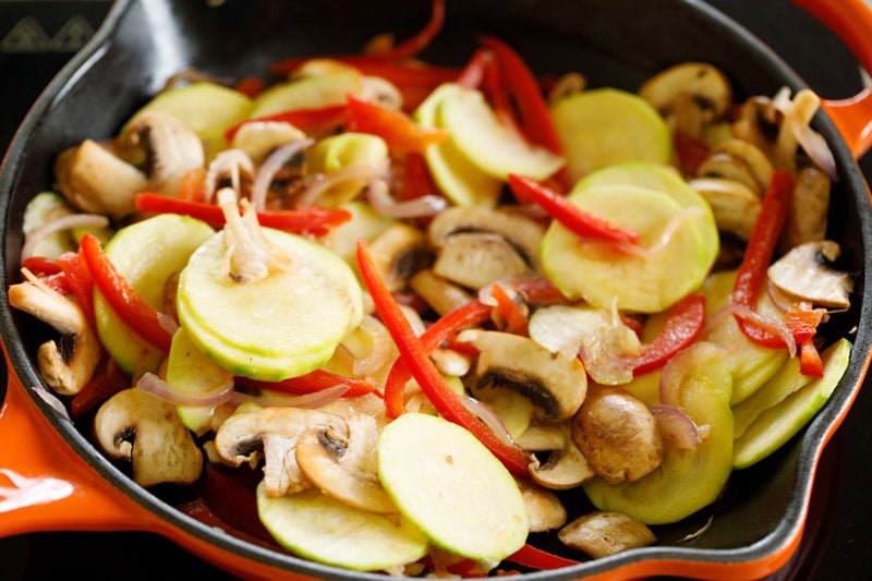 vegetables being sautéed in a skillet.