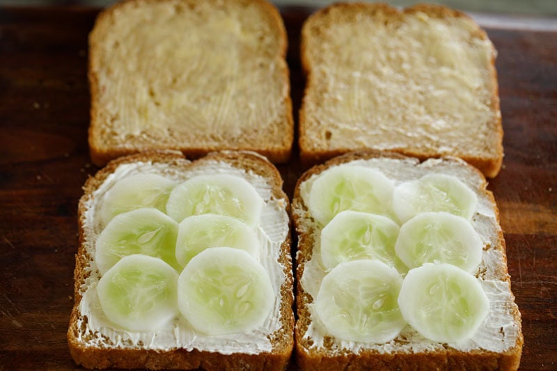 Sliced cucumbers placed on bread with cream cheese spread.