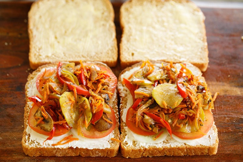 Sautéed vegetable placed on top of tomatoes on bread.
