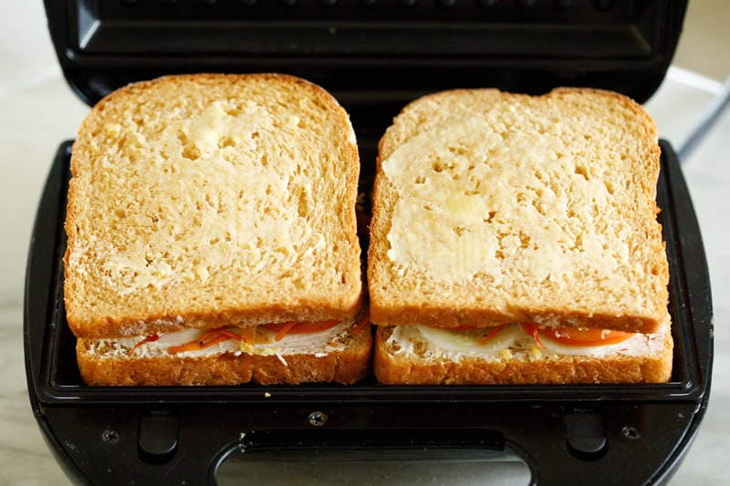 vegetable sandwiches placed in panini press or sandwich grill.
