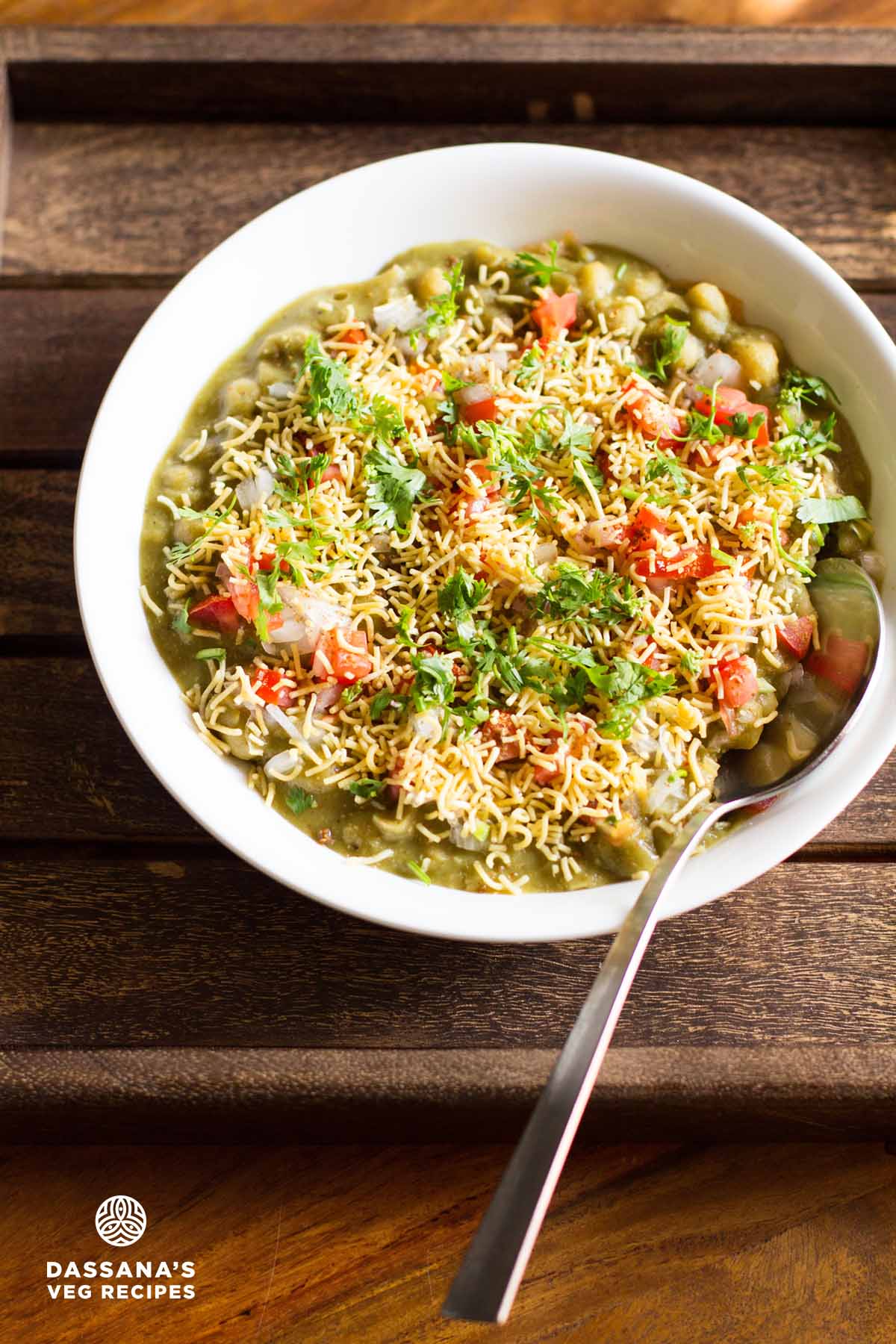 masala puri served in a white bowl with a spoon.