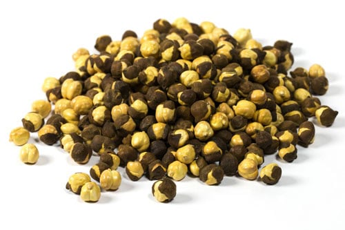 roasted black chickpeas with husk on a white background.