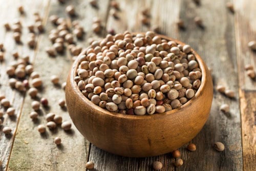 whole toor or pigeon pea in a wooden bowl.