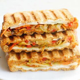 vegetable sandwich stacked on top of each with visible veggie and cheese layers.