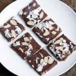 Chocolate barfi with almond toppings and silver foil.